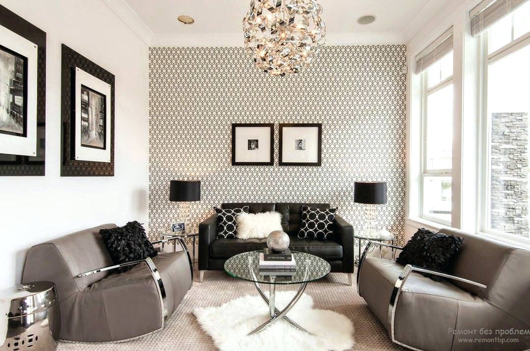 اتاق نشیمن مدرن با مبل های مشکی و خاکستری که از ترکیب کاغذ دیواری سفید و مشکی و دیوارهای سفید رنگ در آن استفاده شده است